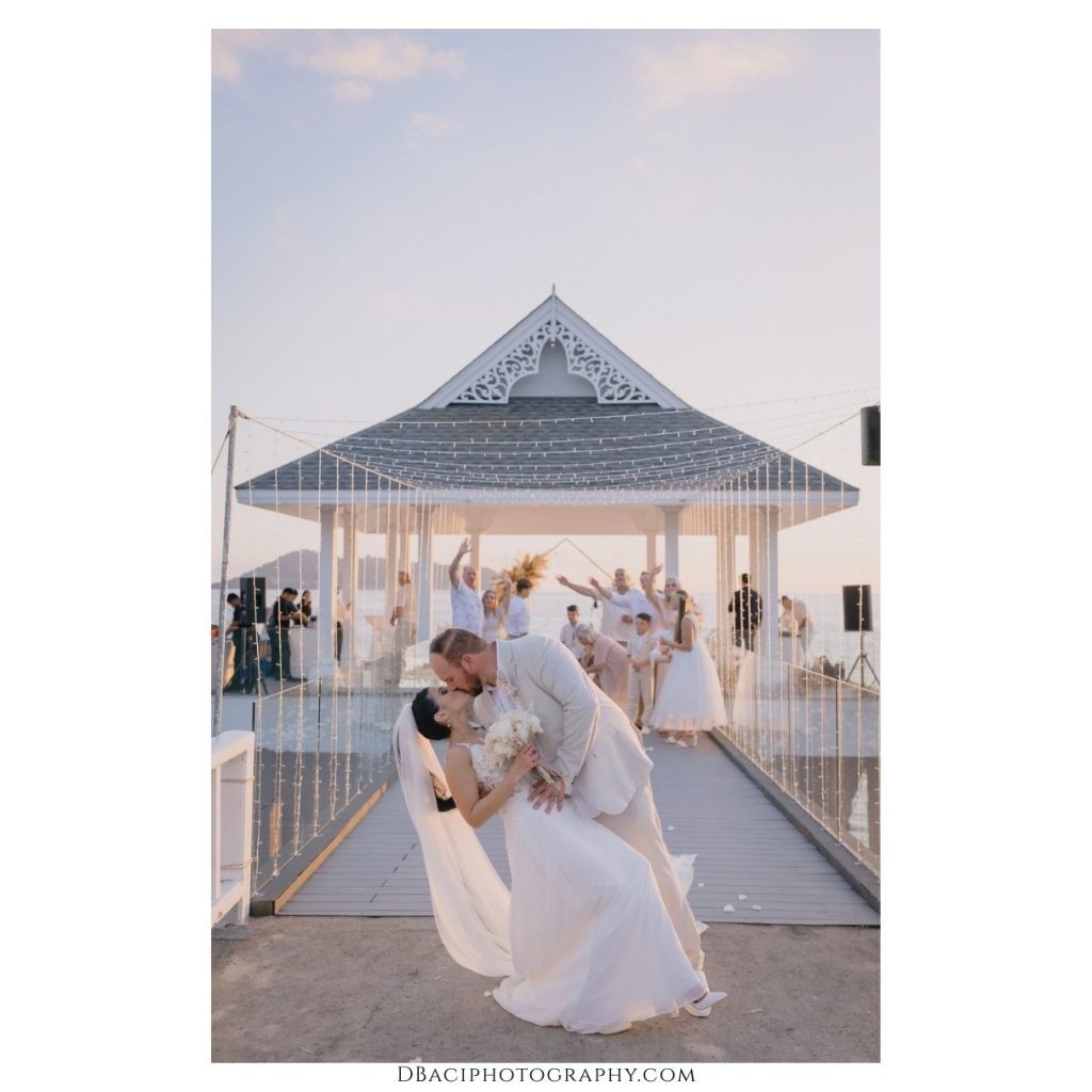 bride and groom kissing after their destination wedding ceremony at Thavorn Beach Village in Phuket. Photo by Thailand wedding photographer, Daniel Baci