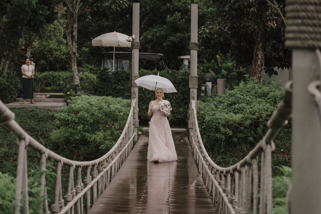 bride walking down the aisle in the rain at Banyan tree wedding in Krabi