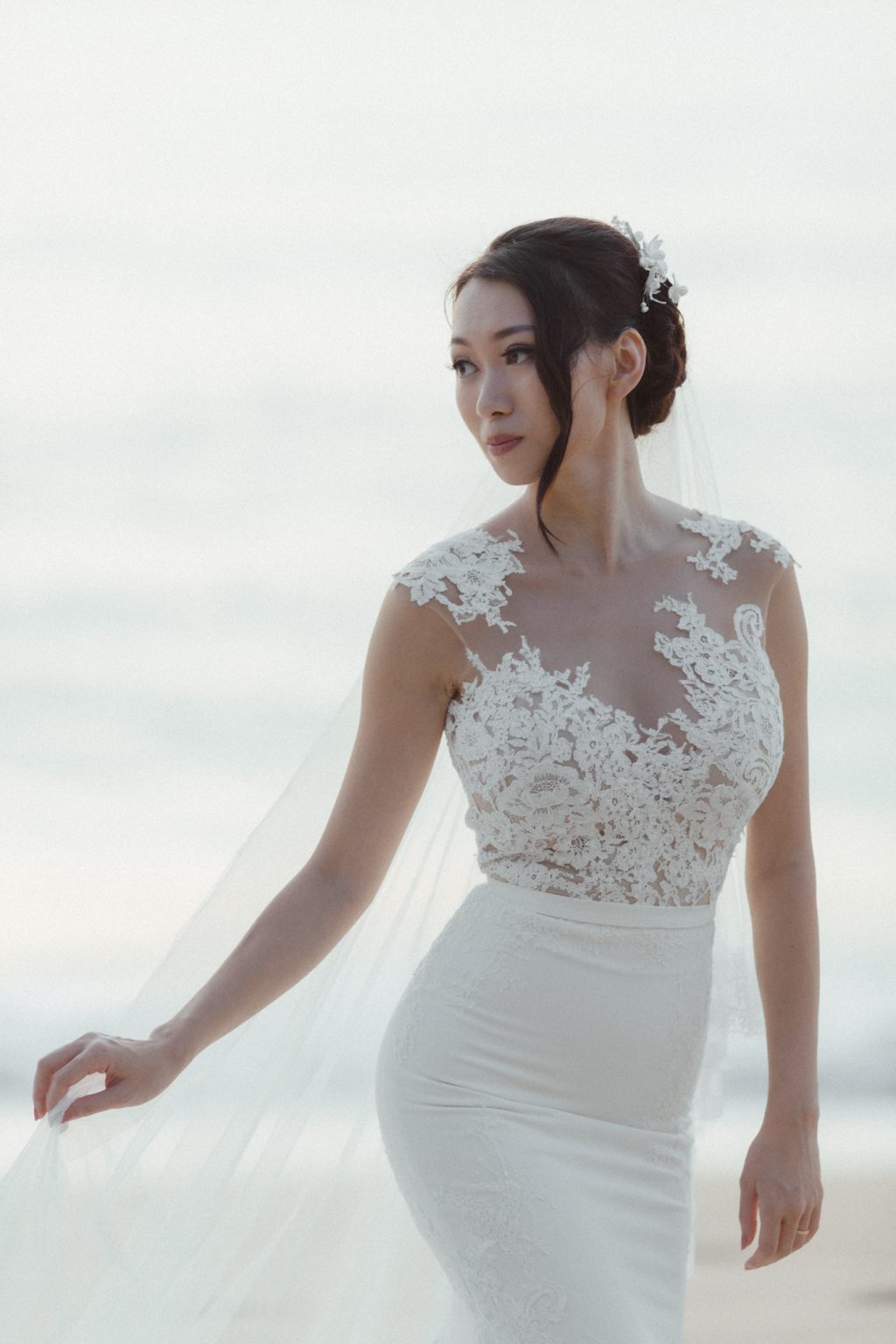 Candid photo of bride from Hong Kong walking on the beach at her destination luxury wedding on Koh Samui. Photography by Daniel Baci