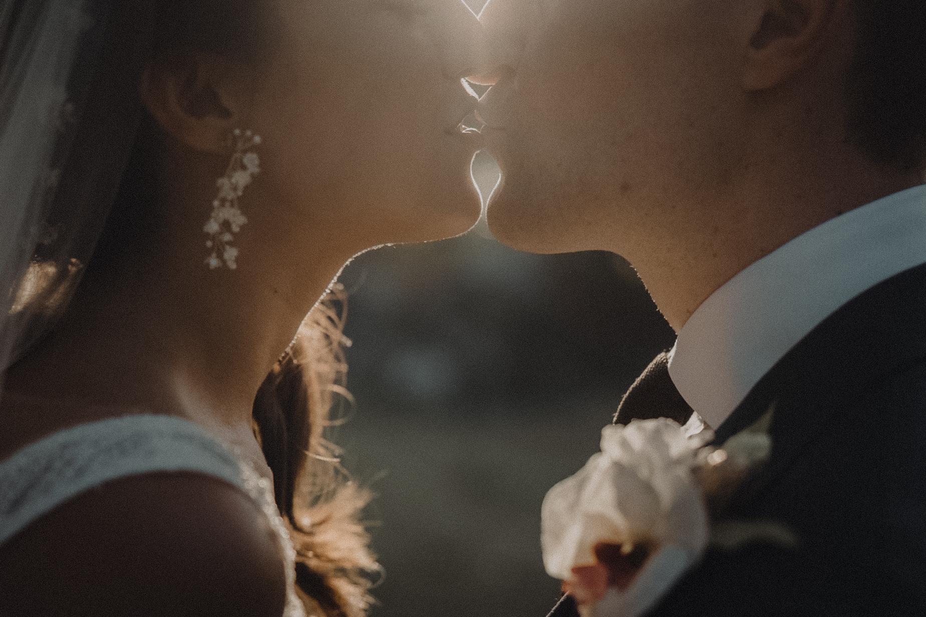UK couple kissing as misty sunlight leaks into frame at their luxury villa wedding in Phuket