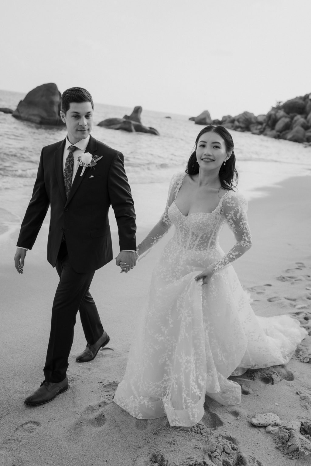 Black and white portrait of bride and groom walking on the beach of Koh Samui at Silavadee Resort & Spa. Photo by Koh Samui wedding photographer