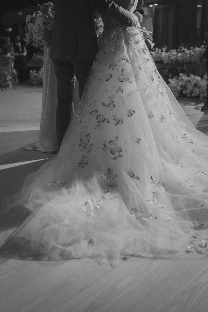 Black and white detail of a bride’s embroidered gown train