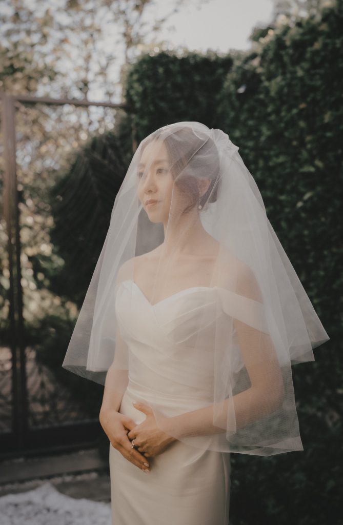 Bride with a short veil in a garden, wedding portrait in Thailand