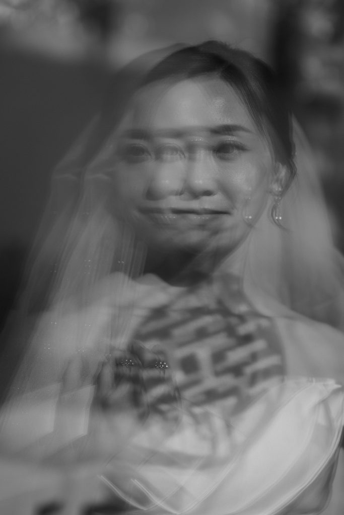 Creative portrait of a Hong Kong bride’s reflection through a window