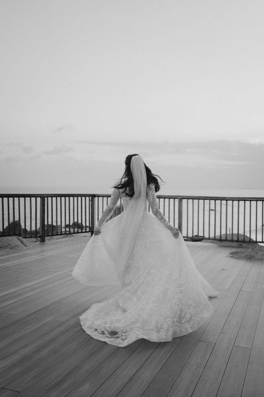 Hong Kong bride twirling her dress on the deck at Salavadee Resort & Spa, Koh Samui, Thailand. Wedding photography by Daniel Baci