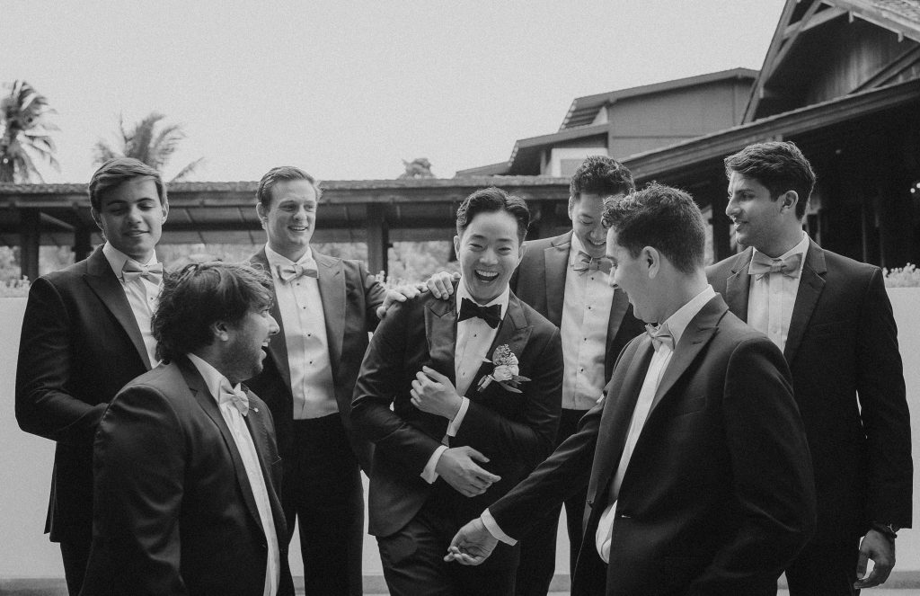 Black and white photo of groomsmen laughing together before the wedding