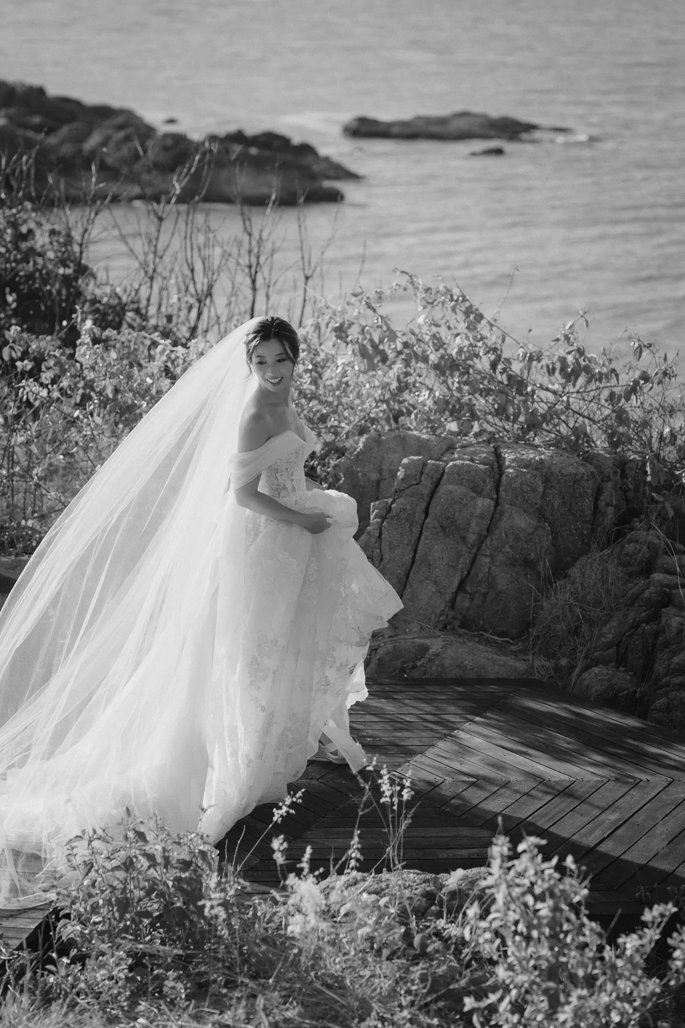 Hong Kong bride holds her dress as she walks at Cape Fahn Hotel in Koh Samui, Thailand. Photo by Thailand wedding photographer, Daniel Baci 