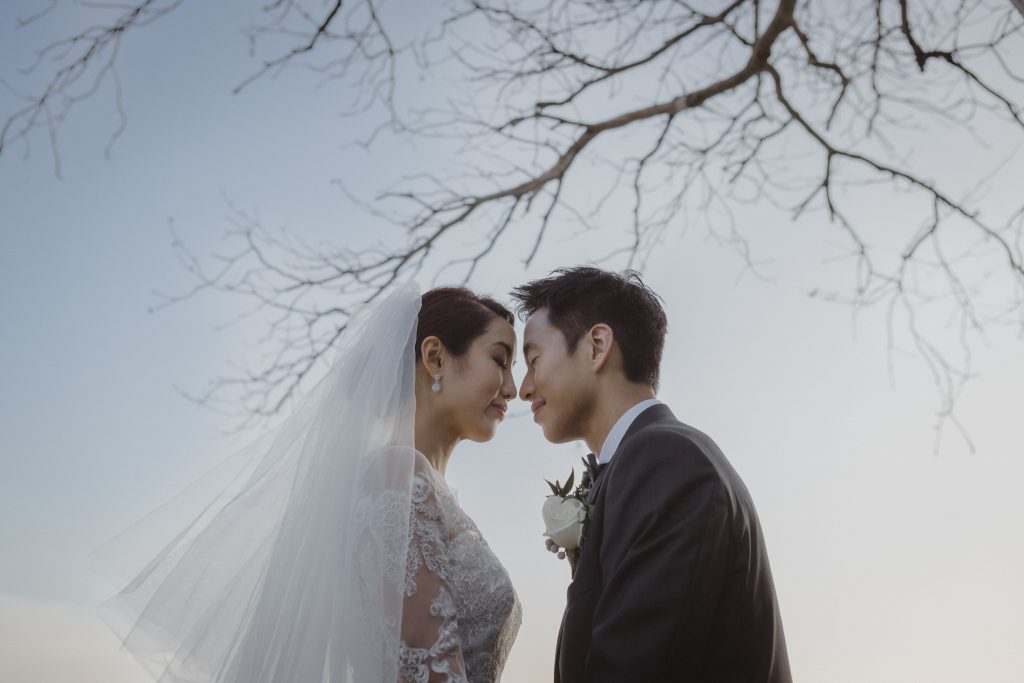 Bride and groom from Hong Kong pose for portrait at their destination wedding in Phuket, Thailand at the Naka Resort.